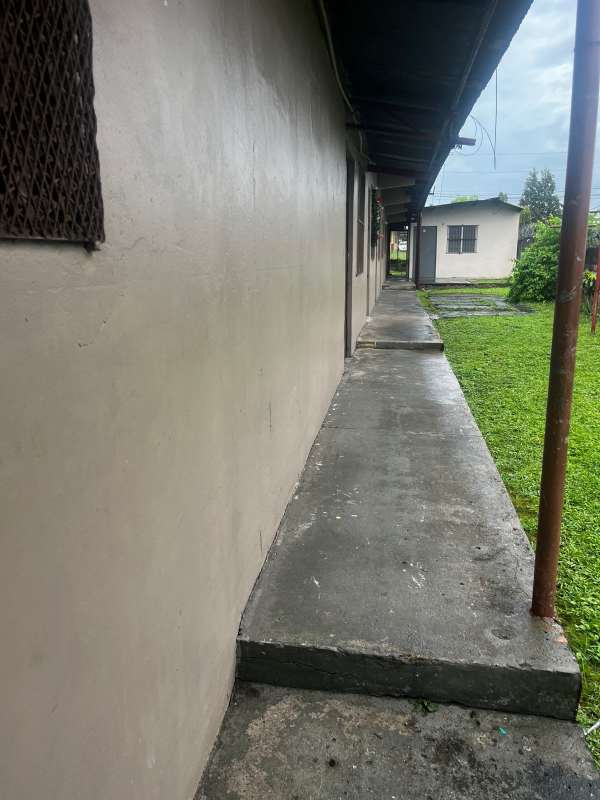 Exterior with concrete walkways, grassy lawn, and rental room buildings in Pedregal land property