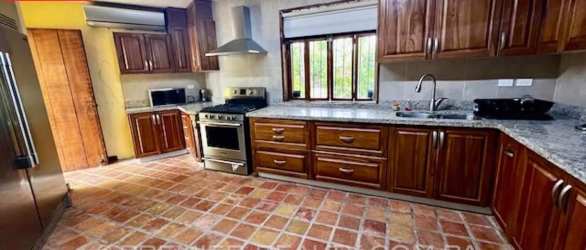 Kitchen with granite countertops, stainless appliances, tile floors, wood cabinets in Coronado villa