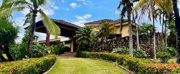 Luxury home with stone wall, palm trees, Mediterranean tiled roof in Coronado Panama for sale