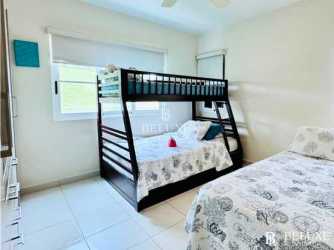 View of multiple infinity pools surrounded by palm trees at Bijao Beach Residences Panama