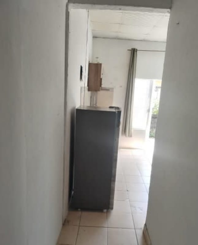 Small corridor leading to compact kitchen with fridge, wall cabinet in Ciudad Radial Panama