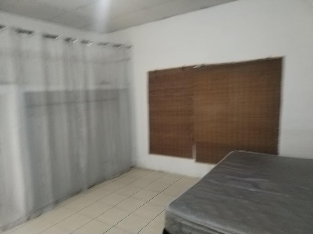 Simple bedroom with tiled floor, mattress, curtains and white walls Panama City