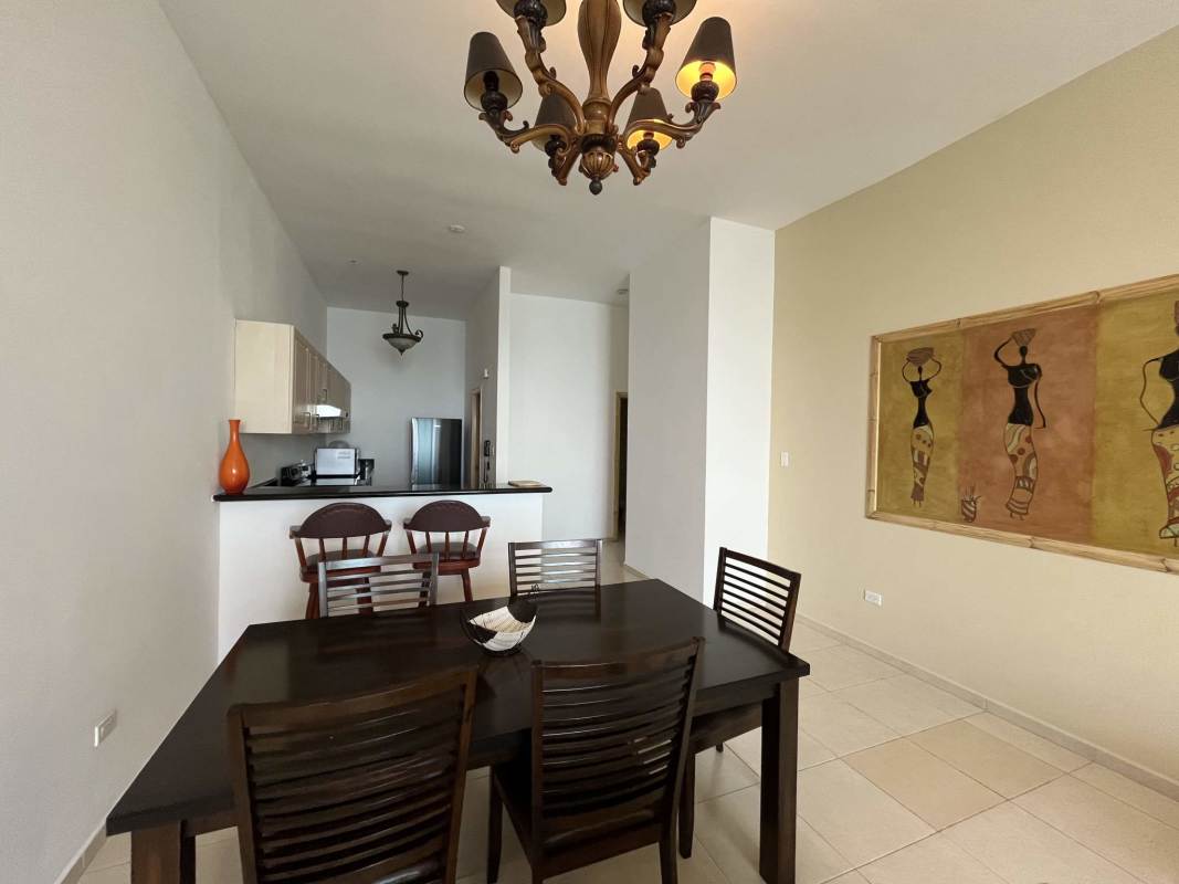 Living and dining with chandeliers, sofas, oceanfront windows in PH BICSA Tower Panama City apartment for rent