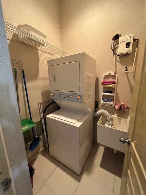 Compact laundry with washer dryer and utility sink in BICSA Tower Panama Apartment