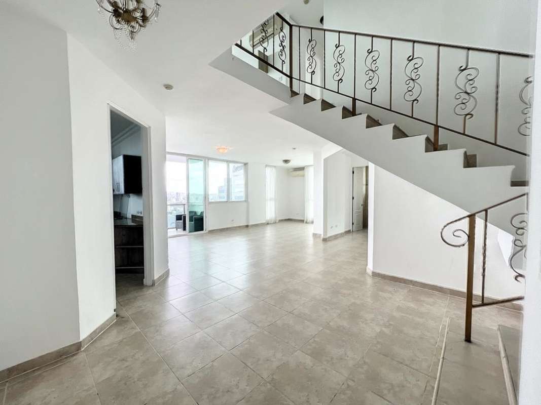Open plan duplex with iron staircase, bright living space, city skyline Mystic Point Panama