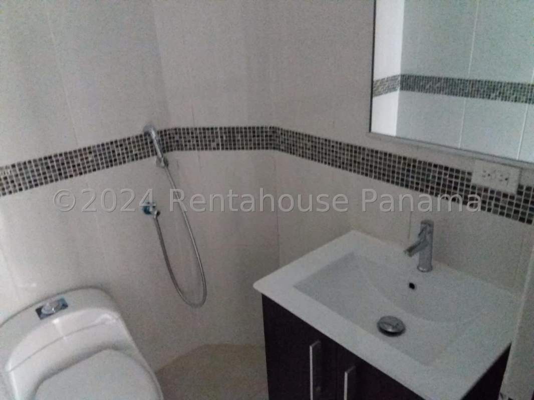 Modern bathroom with glass shower enclosure and mosaic tile accent in Edison Park apartment Panama