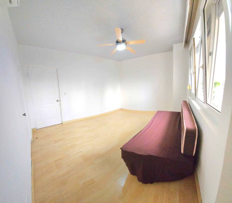 Master bedroom with wood floors large window city view at PH Vistanova Panama City