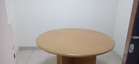 Minimalist small meeting room with round wood table and white walls Plaza Oeste La Chorrera