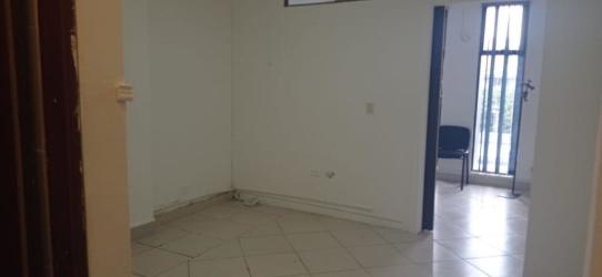 Empty tiled interior room with white walls and security bars window Plaza Oeste La Chorrera