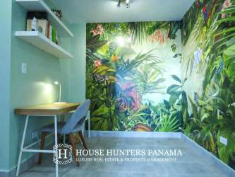 Decorative office nook with jungle-themed accent wall overlooking lush green views