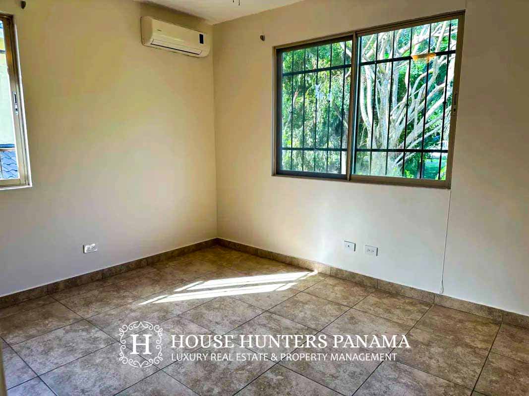 Spacious living room with large sliding glass doors opening to covered balcony in Embassy Club house Clayton Panama