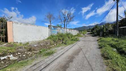 Rural dirt road with concrete boundary wall leading to mountain view lot in Volcán Panama