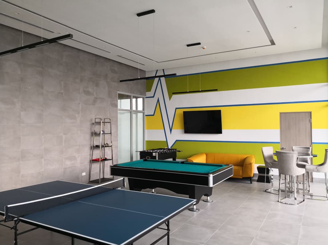 Game room with pool table, ping pong, lounge area, mural, and modern lighting at PH Panoramic Tower Edison Park