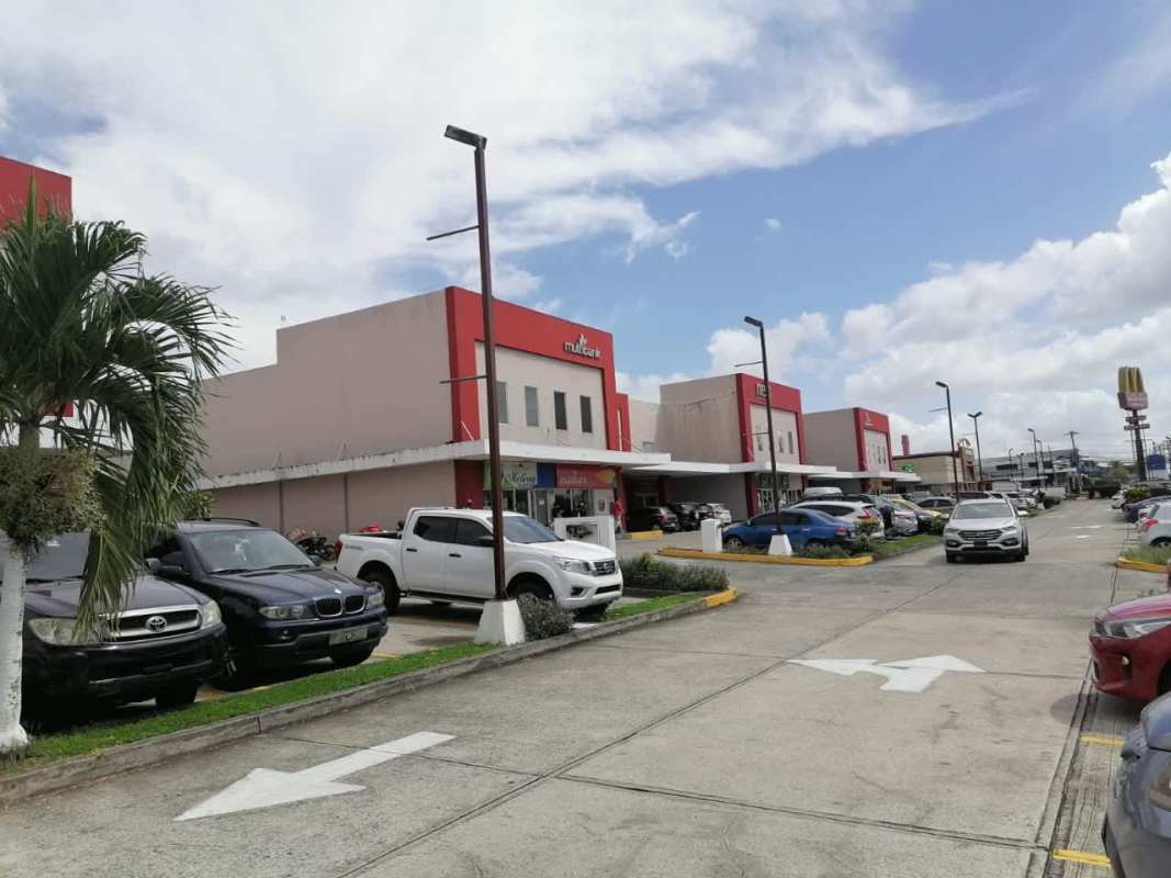 Exterior plaza view with parking spaces, storefronts, palm trees, in Brisas del Golf Panama City