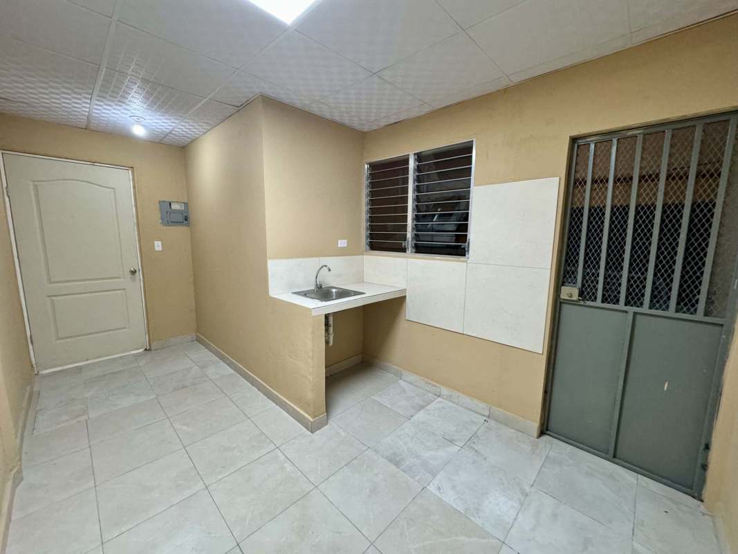 Minimalist kitchen area with sink, tiled floor, security door Parque Lefevre Panama