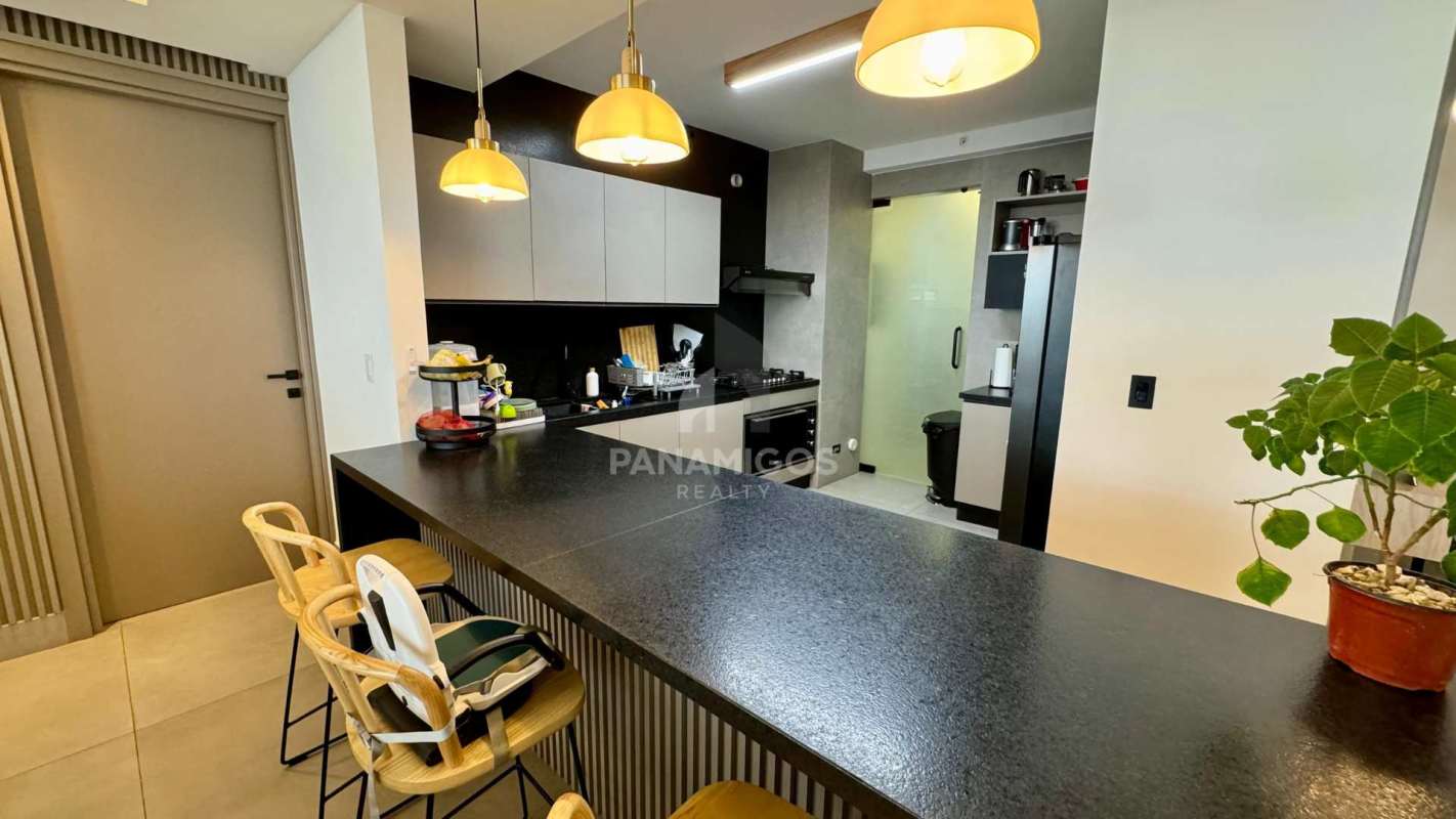 Kitchen with black countertops, breakfast bar, stainless appliances in Coco del Mar Panama
