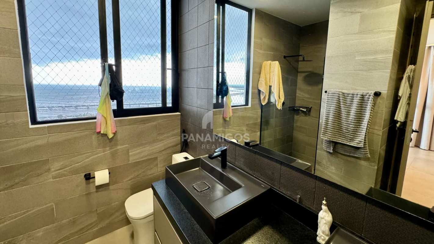 Bathroom with large oceanfront window, gray tile, glass shower in Panama condo
