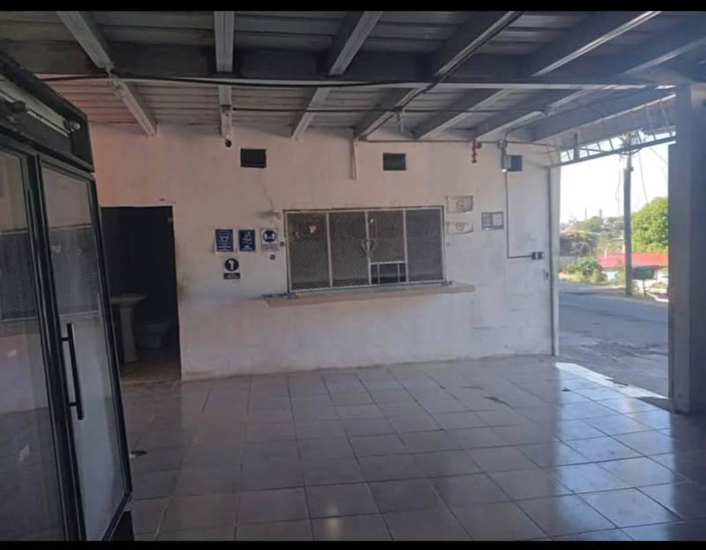 Interior view with tiled floors and service counter behind security mesh in Samaria Panama