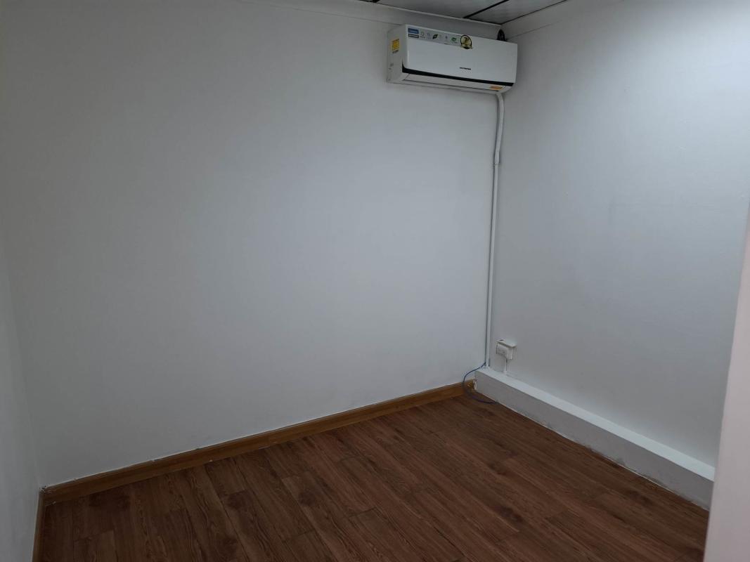 Partitioned minimalist office space with wood flooring and white walls in Villa de las Fuentes Panama City