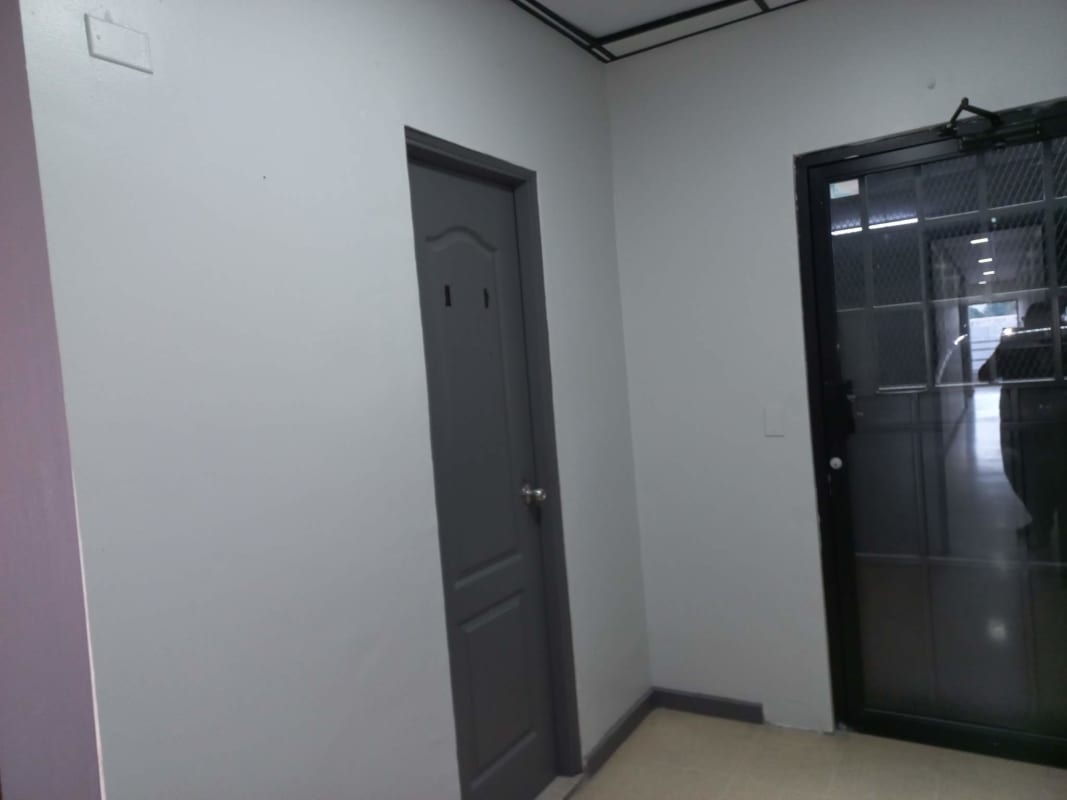 Interior corridor with solid doors, drop ceiling, tile floor in commercial building Panama City