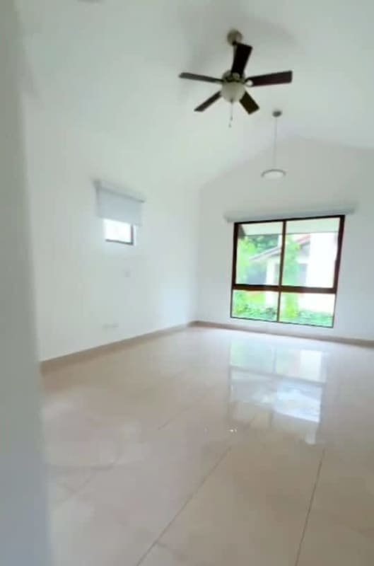Bright living room with marble floors, large window and ceiling fan in luxury home Clayton Panama
