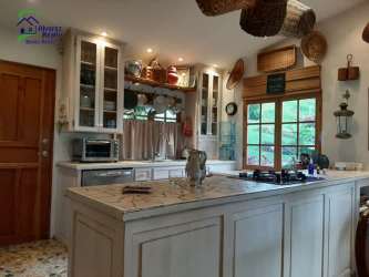 Rustic farmhouse kitchen with marble island, wooden cabinets, large window near Volcán Panama