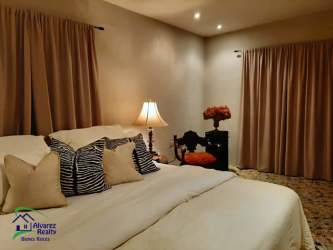 Bedroom with king-size bed, neutral walls, ceiling lighting, rural ranch estate in Panamá countryside