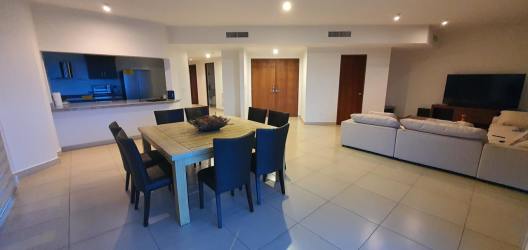 Modern open-plan living dining space with large windows and ocean view