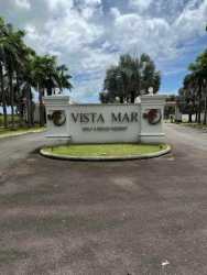Palm-lined entrance road with signage at exclusive Vista Mar community