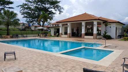 Mediterranean-style clubhouse with large community pool and lounge chairs Costa Verde Panama