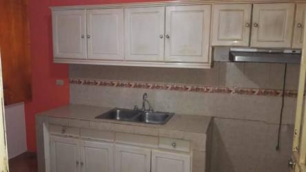 Traditional kitchen with tiled counters, double sink, and cabinets in house Los Santos