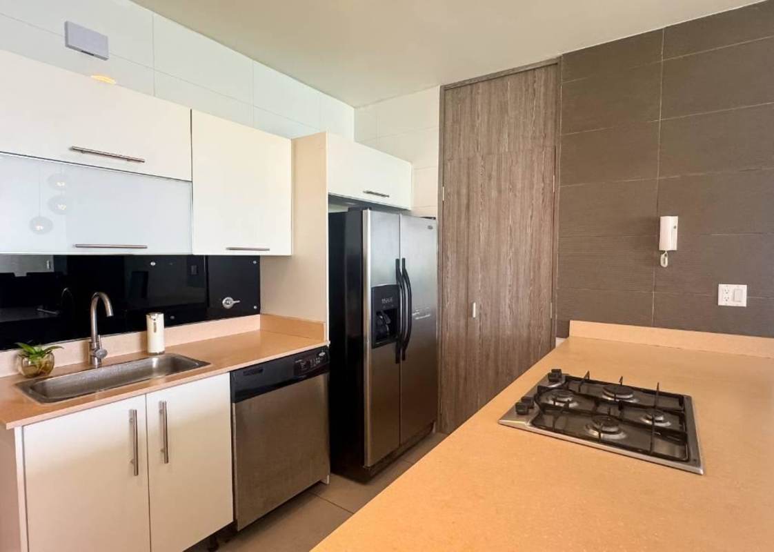 Contemporary kitchen with stainless steel appliances and glossy finishes in PH Element apartment