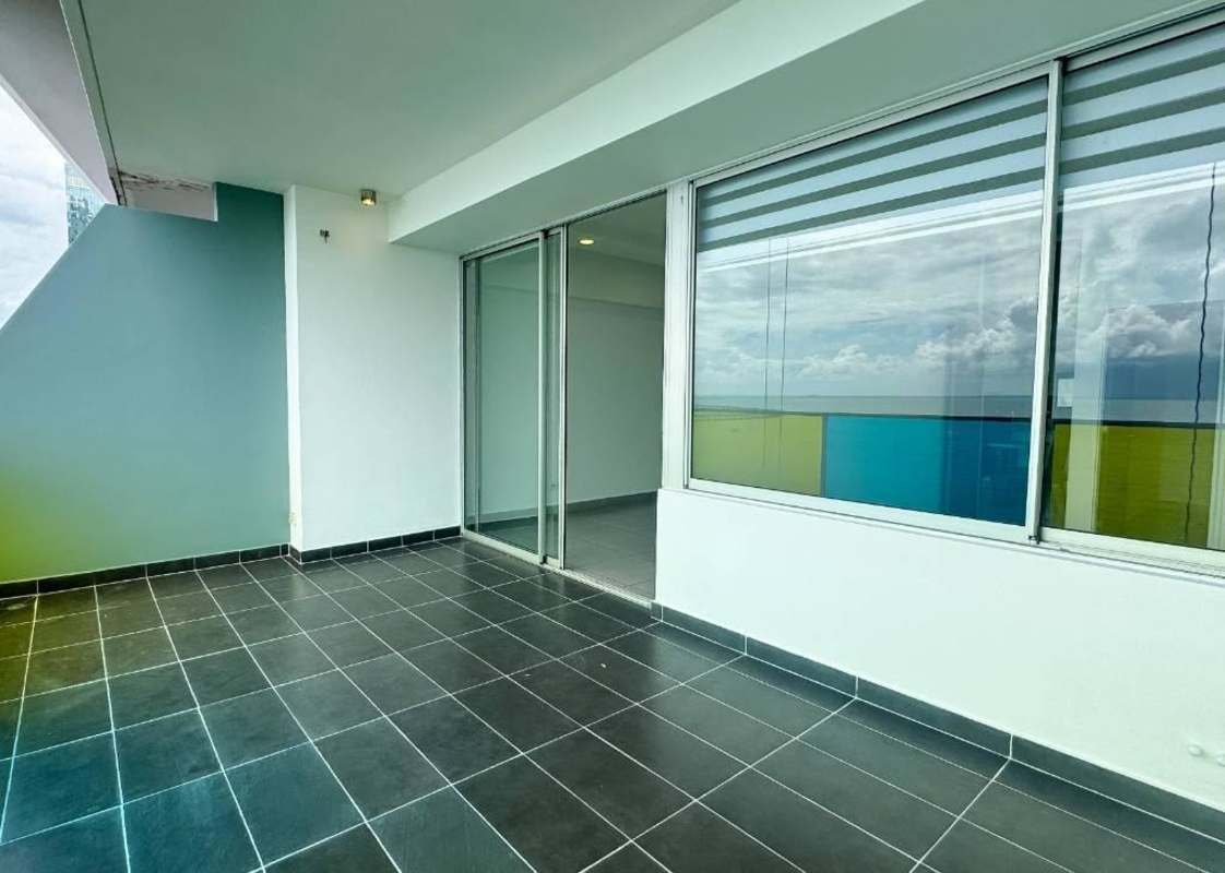Covered balcony with glass railing and colorful panels overlooking Pacific Ocean Panama City