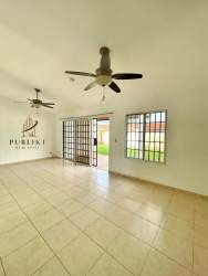 Yellow single story residence with driveway and garden at La Arboleda Costa Verde Panama