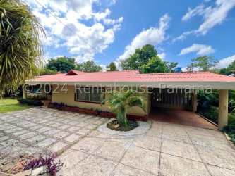 Single-story country house with red roof, garden, wide driveway and carport in Vista Alegre Panama