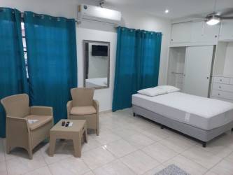 Minimalist bedroom with blue curtains, beige furniture, built-in wardrobe in Penonomé