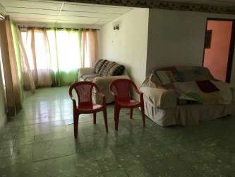 Simple bedroom with wooden wardrobe, tiled floor and natural light residential house Penonomé