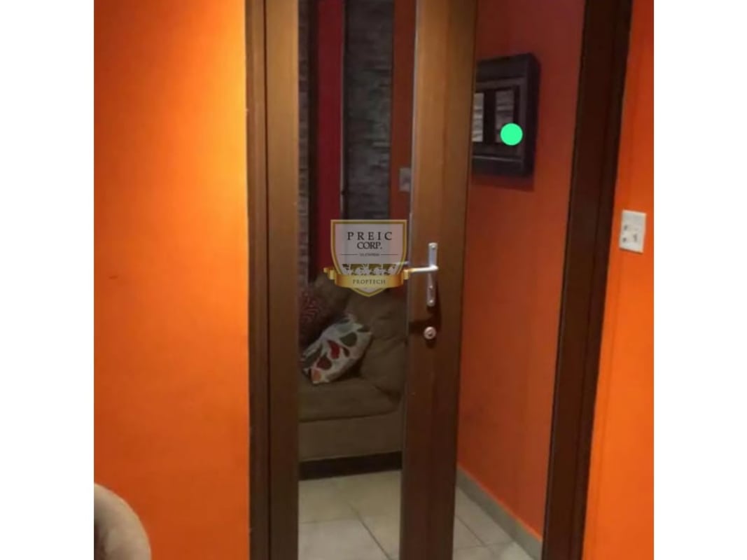 Interior corridor with orange paint mirrored door leading to bedrooms Panama City house