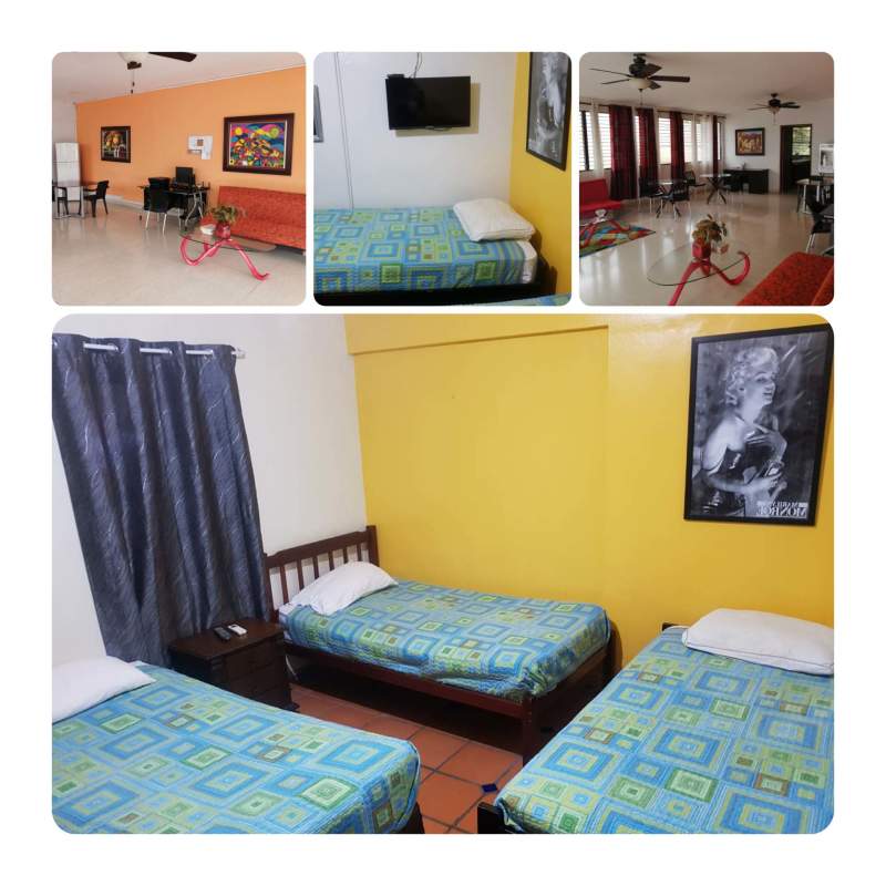 Bright living-dining area with orange accent wall, fan, open living space in El Carmen house