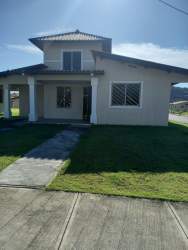 Two-story home with porch green lawn driveway in La Reserva Santiago Panama furnished rental