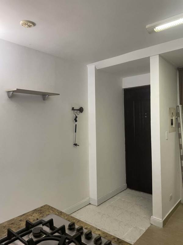 Compact kitchen with granite counter, stove, black door view PH Plaza Bella Vista Panama