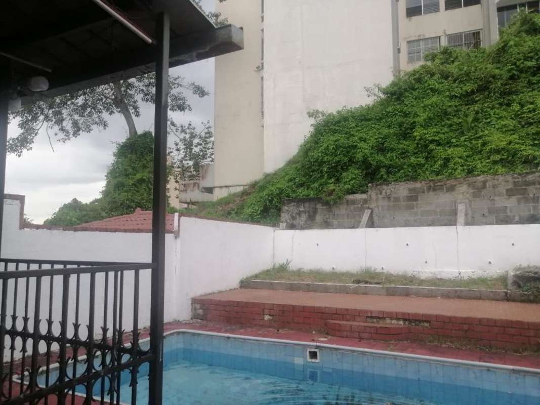 Private swimming pool with patio green gardens at Villa de las Fuentes Panama City