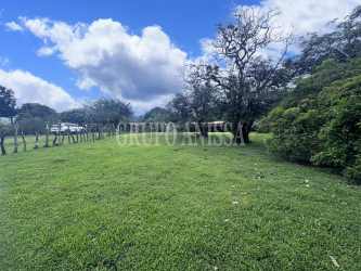Open grassy corner land with trees, mountain views, fenced parts El Valle Coclé Panama
