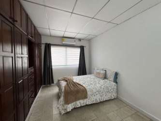 Living room with large windows, sofa, armchairs, ceiling fan, bright decor in Chitré house for sale