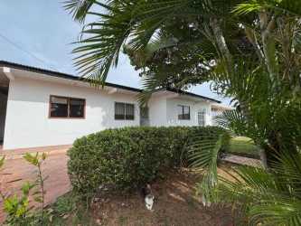 Kitchen with white cabinets, tile backsplash, large window in house for sale in Chitré