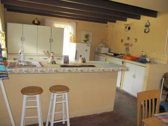 Exterior two-story yellow house with fence trees Brisas del Coronado Panama