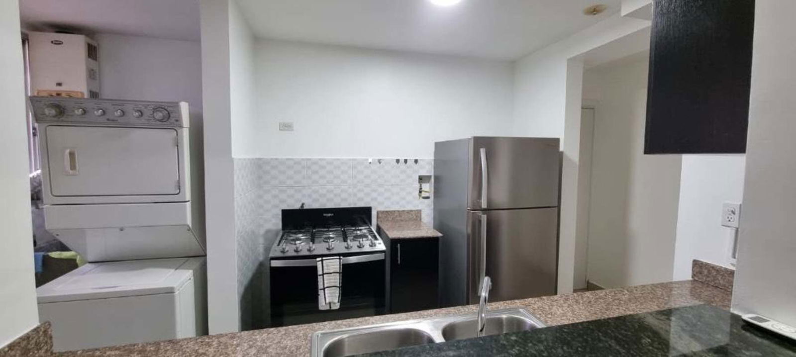 Kitchen with granite counters and breakfast bar overlooking living area PH Parque Lefevre Panama