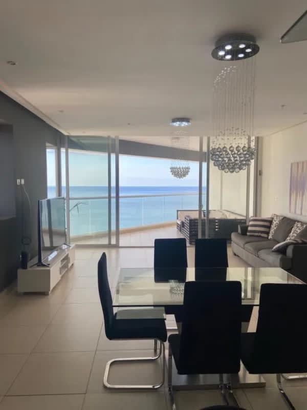 Living and dining area with ocean view, floor-to-ceiling windows, modern furniture Punta Paitilla Panama