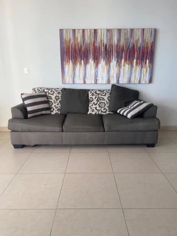 Living room with large sofa, colorful wall art, tile floors oceanfront Punta Paitilla Panama