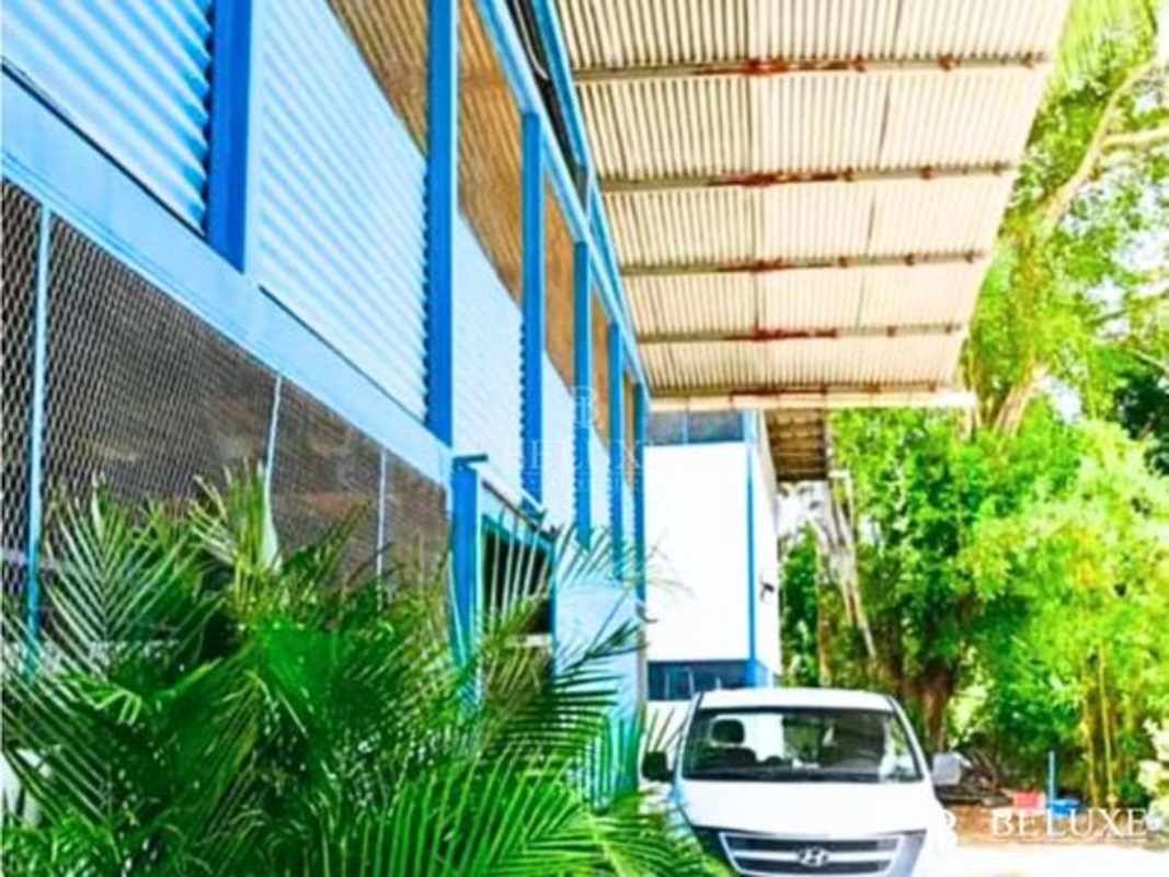 Exterior view covered parking and landscaping at industrial warehouse Pueblo Nuevo